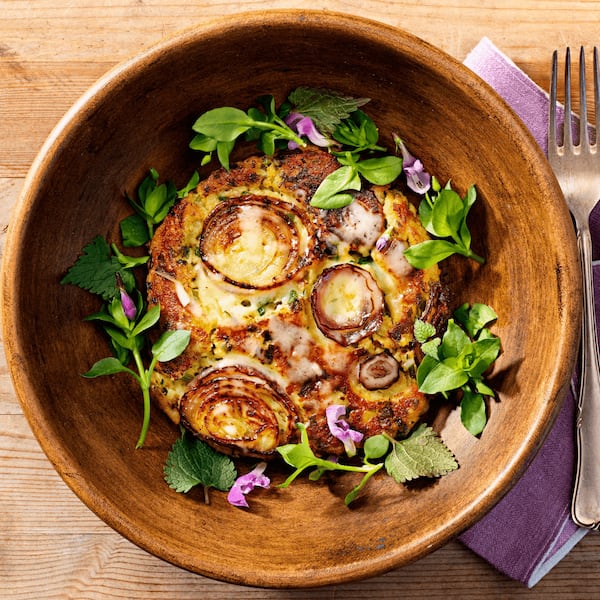 Bärlauch-Erdäpfelpuffer, Wildkräuter, Bergkäse, Holzschüssel, Serviette, Holztisch, Gabel, rote Zwiebel