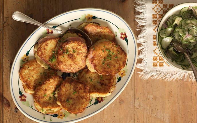 Böhmischer Erdäpfelpuffer mit Prager Schinken, Gurkensalat, Keramikteller, Tischdecke, Holztisch