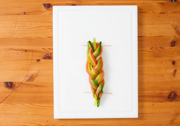 Holzstäbe, geflochtener Lauch-Lachsforellen-Zopf, Brett