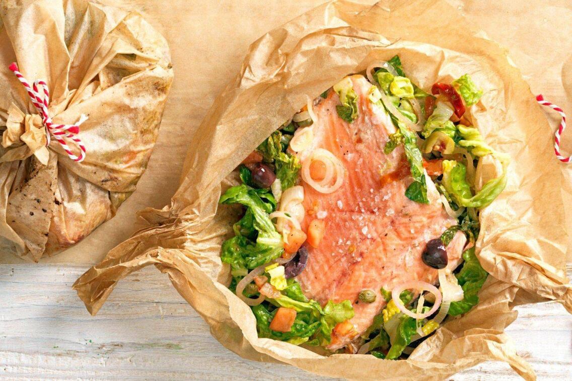 Backpapier, rotweiße Schnur, Packerl gefüllt mit Lachsforellenfilet, Kochsalat, Oliven, Zwiebelringen