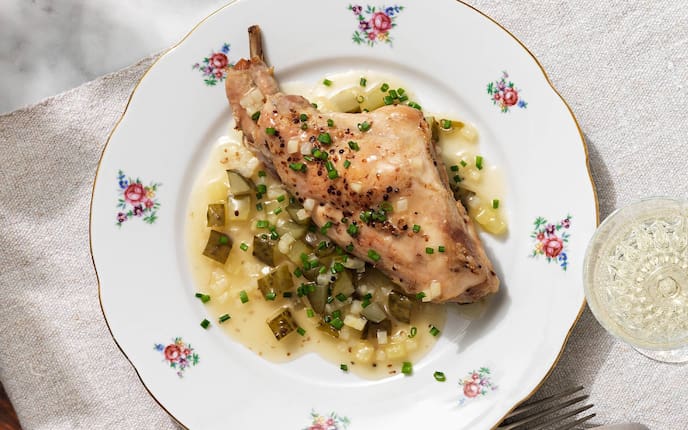 Kaninchenkeule, Gurkerl, Weißwein, Messer, Gabel, Teller