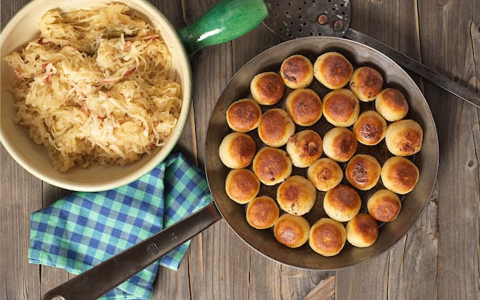 Holzknechtnocken mit Apfelsauerkraut, Reindl, Pfanne, Serviette, Holztisch