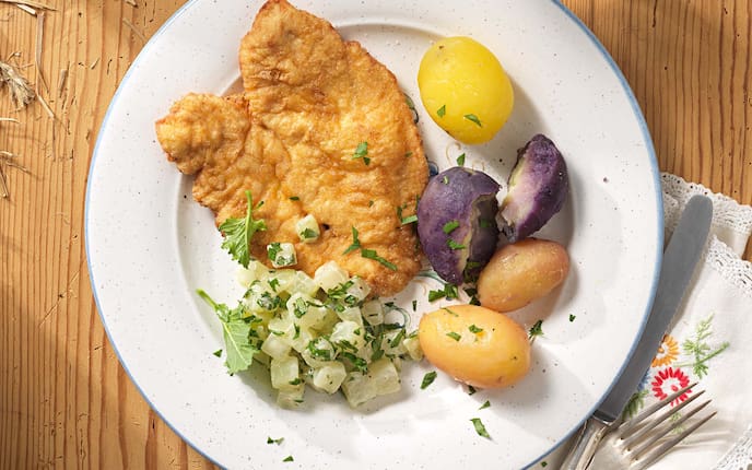 Hühnerschnitzel Pariser Art mit bunten Erdäpfeln und Kohlrabi, Gedeck, Kräuter