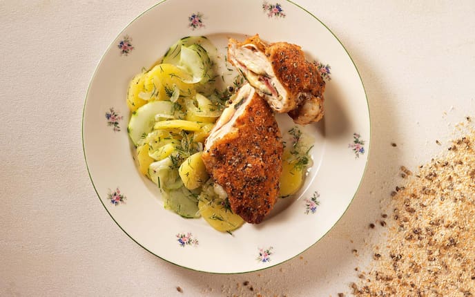 Cordon Bleu vom Hendl in der Hanfpanier, Erdäpfel-Gurken-Salat, Dill, Porzellanteller, Hanfsamen