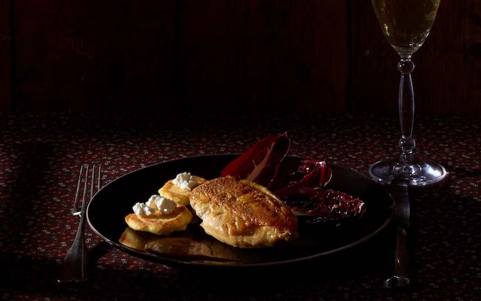 Hendlbrust mit Erdäpfelblinis und glasiertem Radicchio di Treviso, Ziegenkäse Gedeck, Weinglas