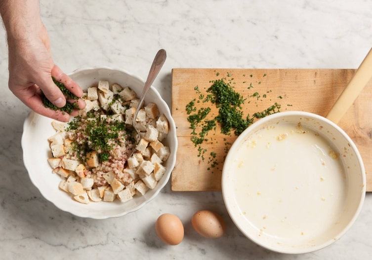 Semmelwürfel, Kräuter, Ei, Milch, Löffel, Schüssel, Hand
