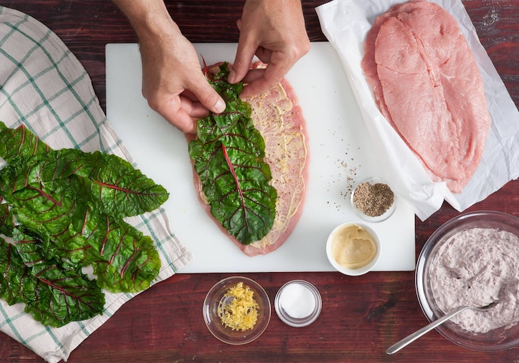 Mangold, Geschirrtuch, Brett, Kalbsschnitzel, Bohnenmasse, Schüsseln, Hände