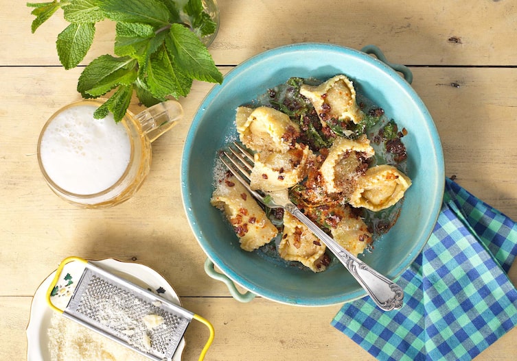 Nudeln mit Schweinefleisch und Minze gefüllt, Parmesan, Serviette, Bier