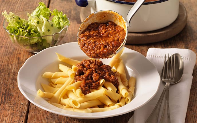 Röllchen mit Faschiertem, Schöpfkehle, Besteck, grüner Salat, Serviette, Kochtopf, Holzbrett, Holztisch, Teller