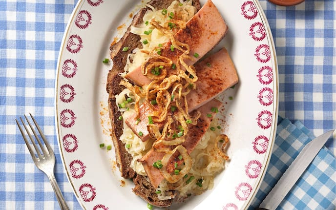 Schwarzbrot, Sauerkraut, Senf, Leberkäse, Röstzwiebel, Gabel, Messer, Serviette