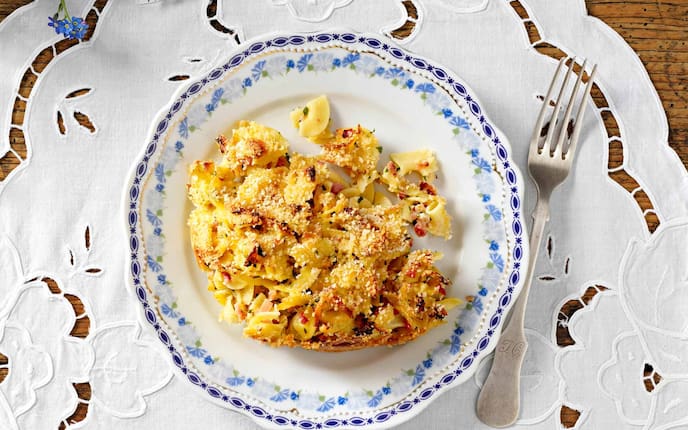 Überbackene Schinkenfleckerl, Omas Kochbuch, Semmelbröseln, Teller, Tischdecke, Gabel, Nudeln, Holztisch