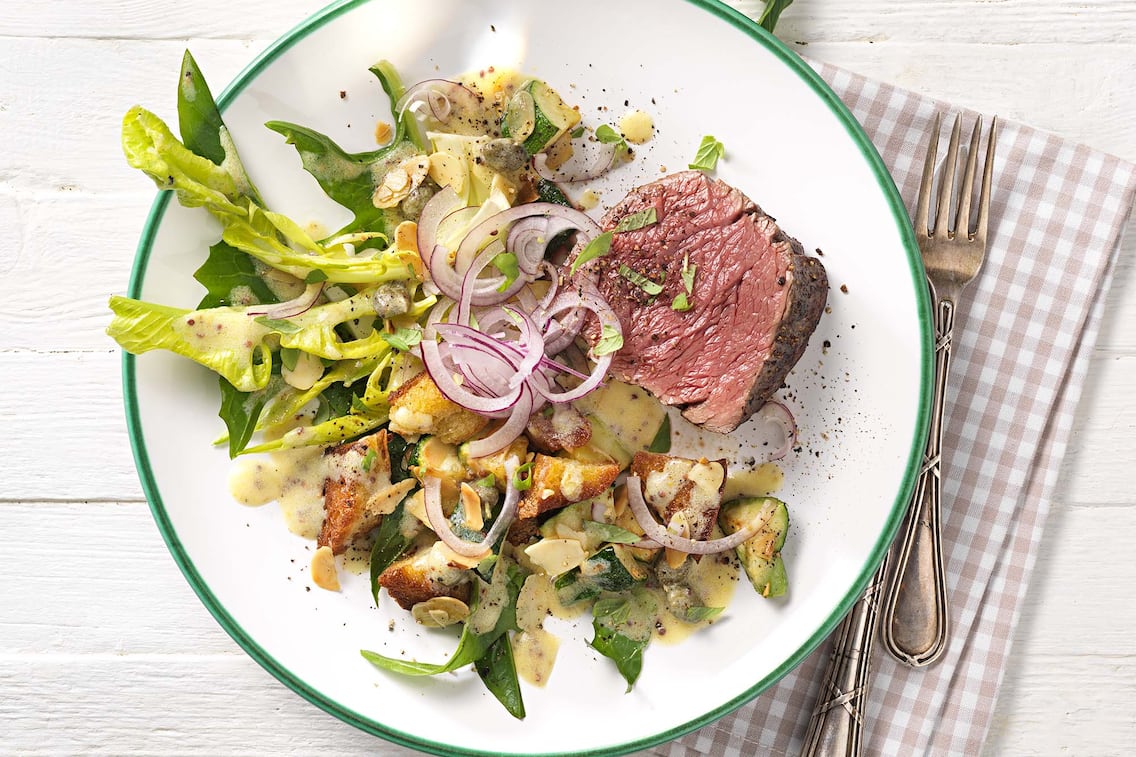 Rindfleisch mit Zucchini-Löwenzahn-Salat, rote Zwiebel, Besteck, Serviette, Kräuter