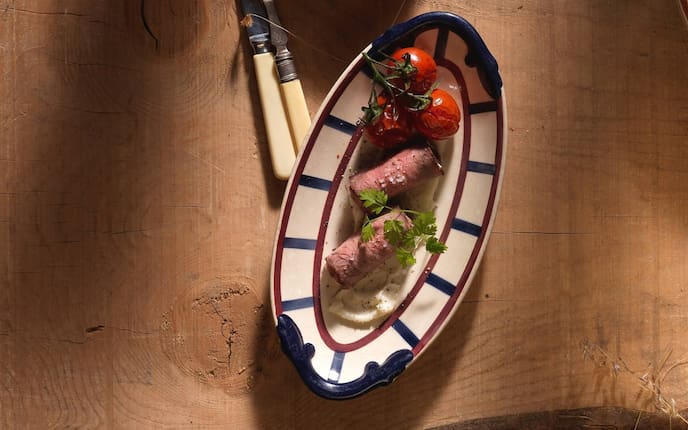 Rindfleischröllchen, Sellerie, glacierte Tomaten, Petersilie, Besteck, Teller