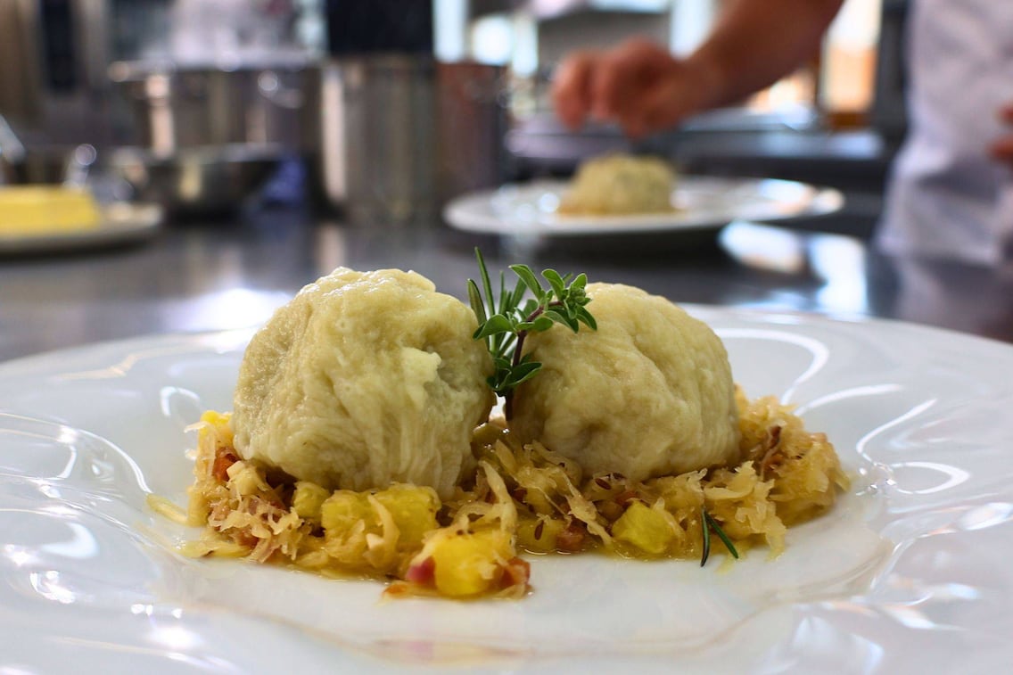 Knödel im Strudelteig auf Speckkraut gebettet.
