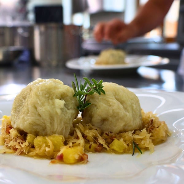 Knödel im Strudelteig auf Speckkraut gebettet.