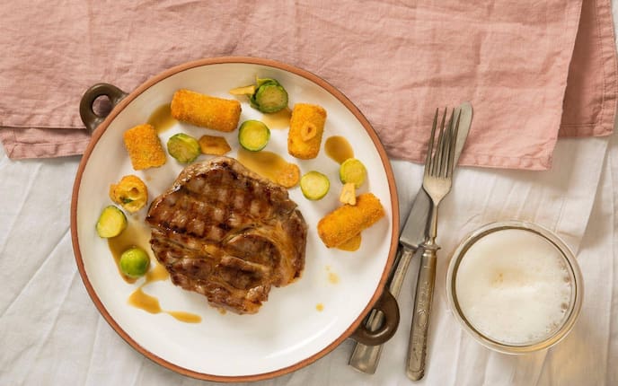 Gegrillter Schweinsschopf, Kroketten, Kohlsprossen, Sauce, Bier