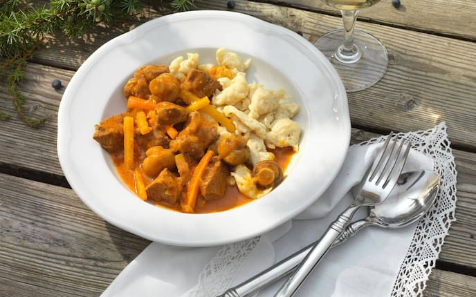 Wacholderfleisch, Eiernockerl, Weißwein, Suppenteller, Besteck, Serviette, Wacholderzweige, Holztisch, Hauptspeise, Schweinefleisch, Servus Rezept