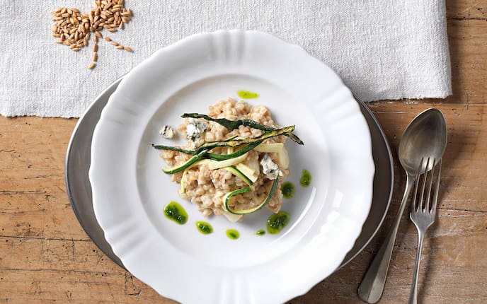Cremiger Dinkel mit Schwarzwurzeln, Zucchini und Schnittlauchöl, Teller, Holztisch, Dinkelkörner, Blauschimmelkäse