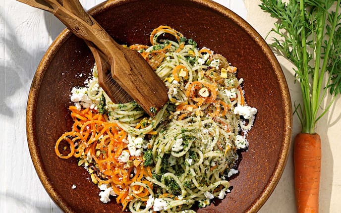 Karottennudeln mit Pesto, Karottengrün, Schüssel, Salatbesteck, Sultaninen, Pistazien