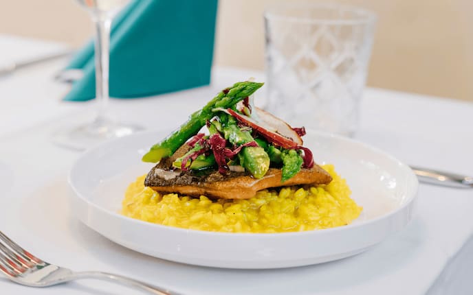 Kärntner Låxn mit Zitronen-Safran-Risotto und Lavanttaler Spargel, Wirthaus-Rezept, Wasserglas, Serviette, Besteck, Teller, Weinglas