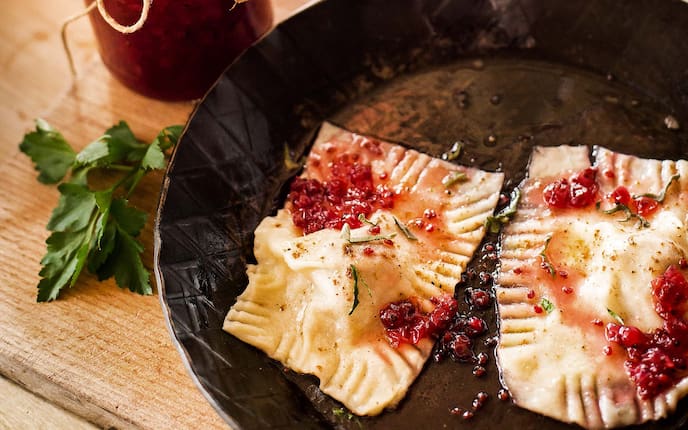 Rehschlutzer mit Ribiselbutter, Pfanne, Kräuter, Holztisch