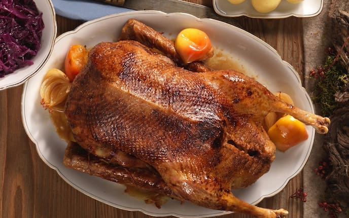 Gans, Rotkraut, Apfelrotkraut, Erdäpfelknödel, Serviette, Holztisch