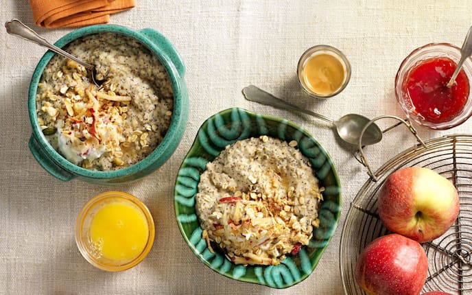 Haferbrei mit Mohn, geraspelter Apfel in Topfen angerührt und auf dem Brei serviert, in grünen Suppenschüsseln serviert. Mit einem Glas Orangensaft, einem Espresse und einem kleinen Glasschüsserl mit Erdbeermarmelade in der ein Teelöffel steckt. Daneben steh ein kleiner Dratkorb, mit frischen Äpfeln gefüllt.