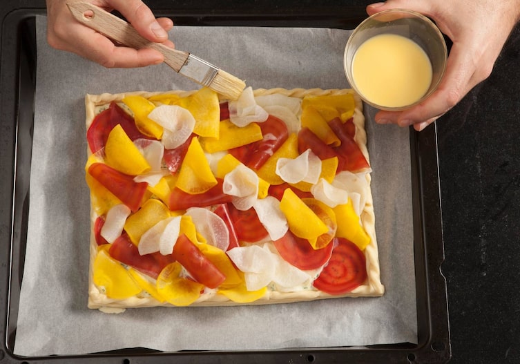 Blätterteigtarte, Rüben, Blätterteig, Dottermilch, Pinsel, Hände