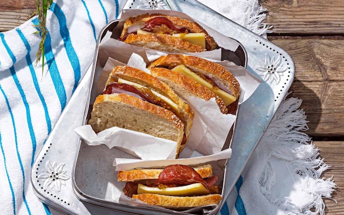 Sandwich mit Rinderschinken und Zwiebelmarmelade, Bergkäse, Jausenbox, Butterpapier, Handtuch, Kastenbrot