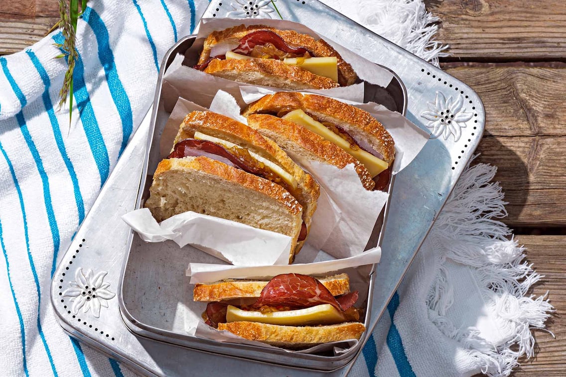 Sandwich mit Rinderschinken und Zwiebelmarmelade, Bergkäse, Jausenbox, Butterpapier, Handtuch, Kastenbrot
