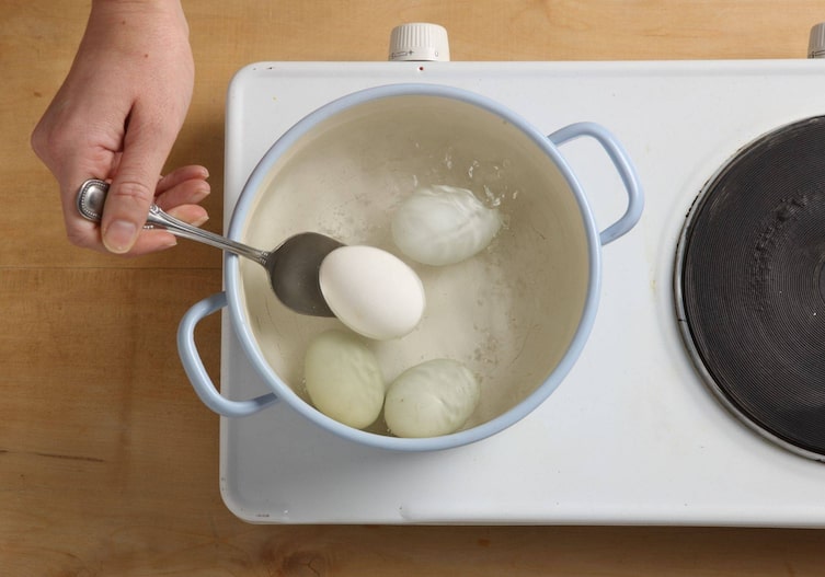 Tee-Eier, Kochtopf, Löffel, Wasser, Herdplatte