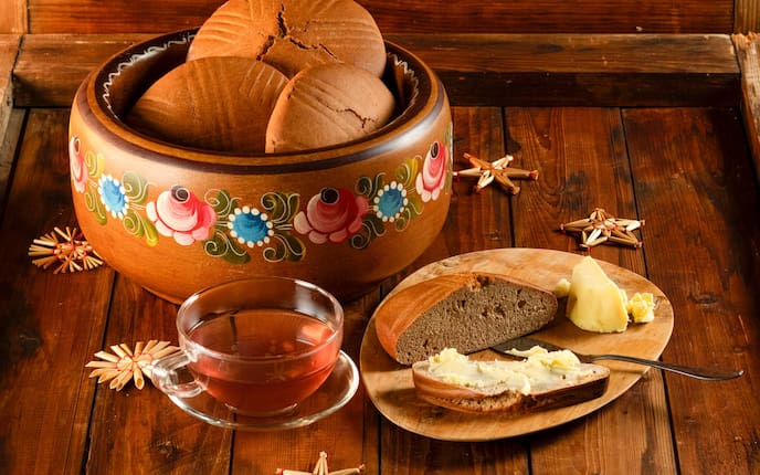 Lebkuchen, Honigbümmel, Holzschale, Teetasse, Tee, Teller, Messer, Strohsterne