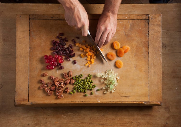 Messer, Brett, Nüsse, Dörrmarillen, Zitronat, Cranberry, Hände