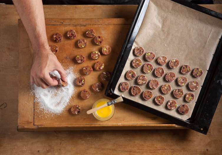 Hand, Kristallzucker, Kekse, Ei, Pinsel, Holzbrett, Backblech, Backpapier