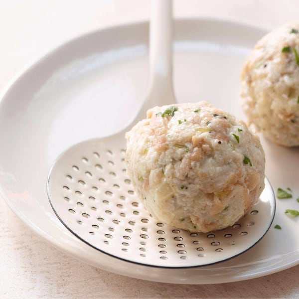 Klassische Semmelknödel auf einem Lochschöpfer.