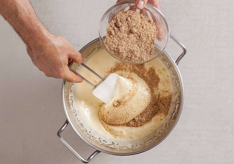 Geriebene Mandeln werden langsam in die Kuchenmasse untergehoben.