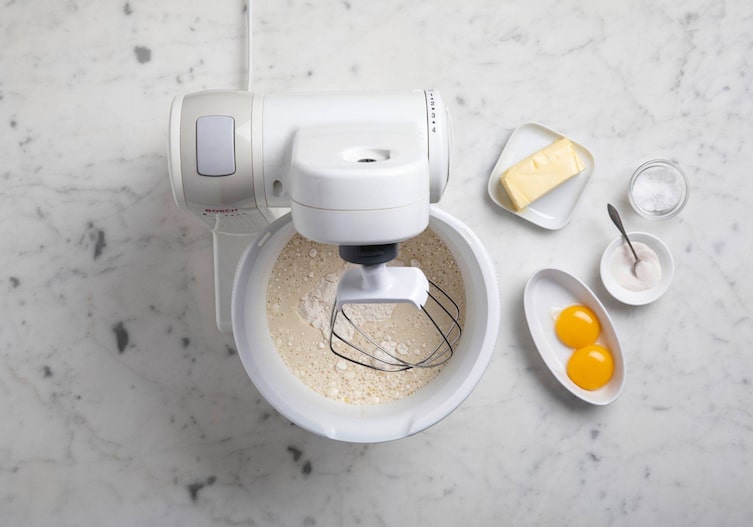 Küchenmaschine mit Dampfl, Mehl, Butter, Eiern, Dotter, Zucker und Salz