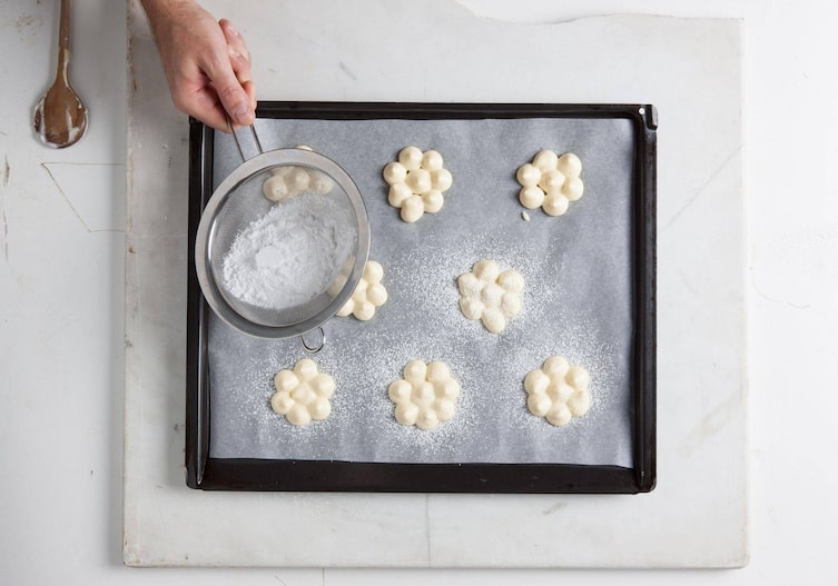 Sieb, Staubzucker, Kochlöffel, Backblech, Backpapier, Biskuitteig