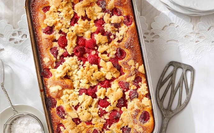 Himbeerkuchen mit Joghurt und Streuseln, Kuchenrein, Tischdecke, Teller, Staubzucker, Sieb