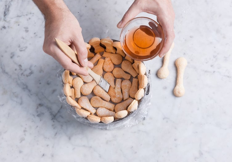 Biskotten, Rum, Pinsel, Tortenring, Frischhaltefolie, Hände