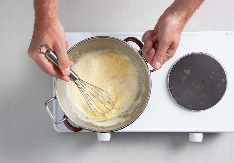 Blüteneis mit heißen Himbeeren, Creme, Schneebesen, Herdplatte