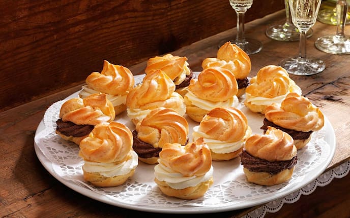 Brandteigkrapfen, Schokocreme, Vanillecreme, Vanilleobers, Teller, Holztisch