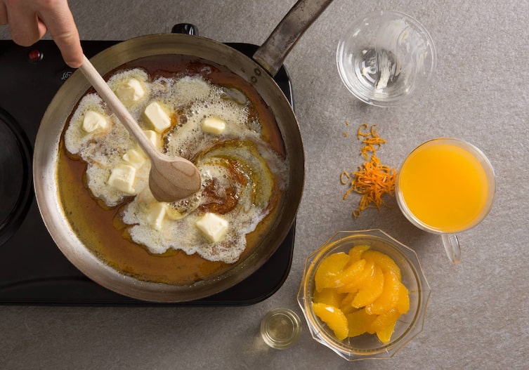 Crêpes Suzette, Orangen, Butterwürfel, Kochlöffel, Karamellstücke