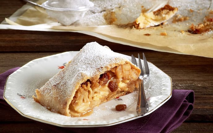 Apfelstrudel, Rosinen, Staubzucker, Gabel, Teller