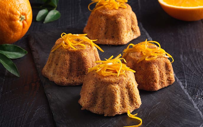 Mandel-Orangen-Törtchen, Orangenblätter, Orangenzesten, Steinplatte, Holztisch