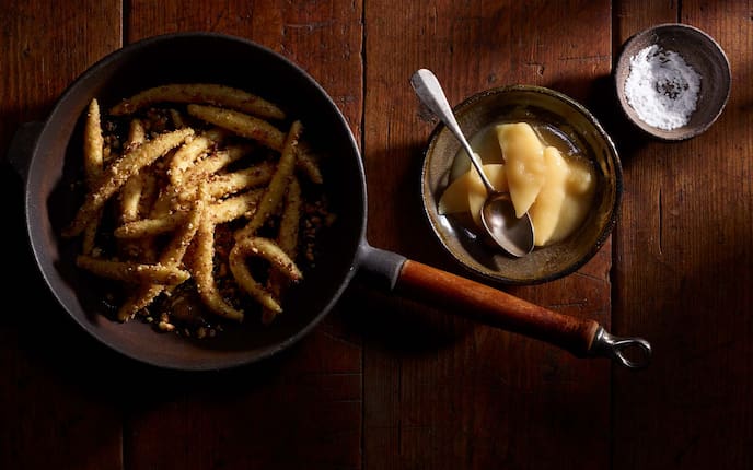 Mandelschupfnudeln mit Zimt und Essigquitte, Staubzucker, Brösel, Mandeln, Pfanne, Schüsseln, Löffel, Holztisch