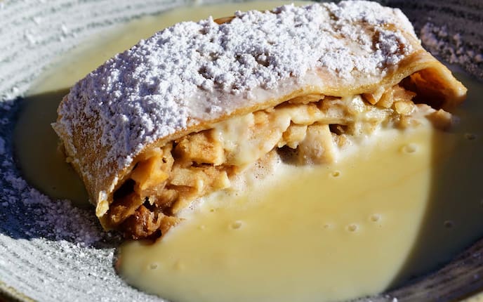 Mostschaum für Apfelstrudel, Staubzucker, Rosinen, Teller, Pudding, Zimt