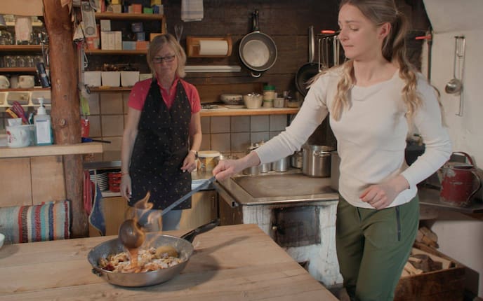 Paula Bründl auf der Halseralm in der Küche und flambiert den Kaiserschmarrn in der Pfanne