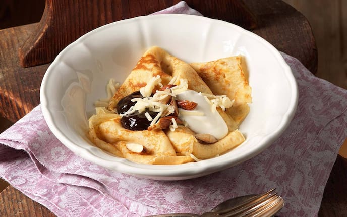 Powidlpalatschinken mit Sauerrahm und Marzipan, Mandeln, Suppenteller, Besteck, Serviette