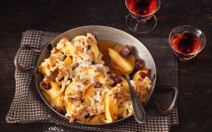 Überbackene Maschansker-Äpfel, Preiselbeeren, Staubzucker, Löffel. Reindl, Küchentuch